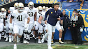 Nov 15, 2025; Pittsburgh, Pennsylvania, USA;  Notre Dame Fighting Irish head coach Marcus Freeman (right) leads the team onto the field to play the Pittsburgh Panthers at Acrisure Stadium. Mandatory Credit: Charles LeClaire-Imagn Images