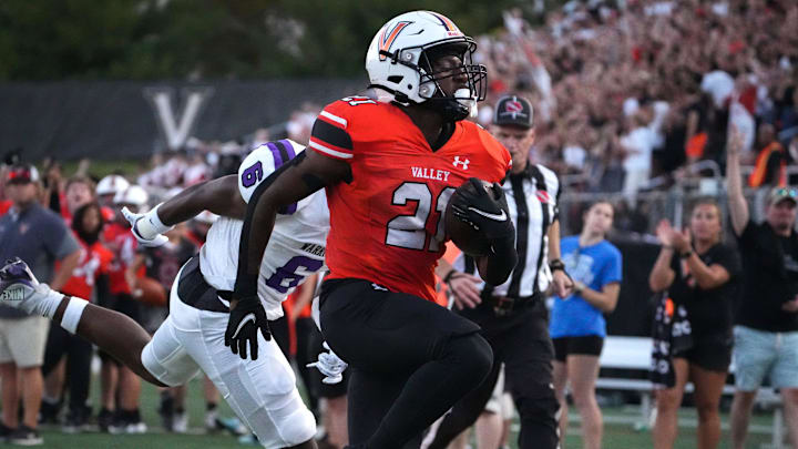 Valley senior running back Jahkari Clark (21) beats Waukee junior safety Jai White into the end zone for a touchdown in the first quarter during a Class 5A football game at Valley Stadium in West Des Moines on Friday, Sept. 20, 2024.