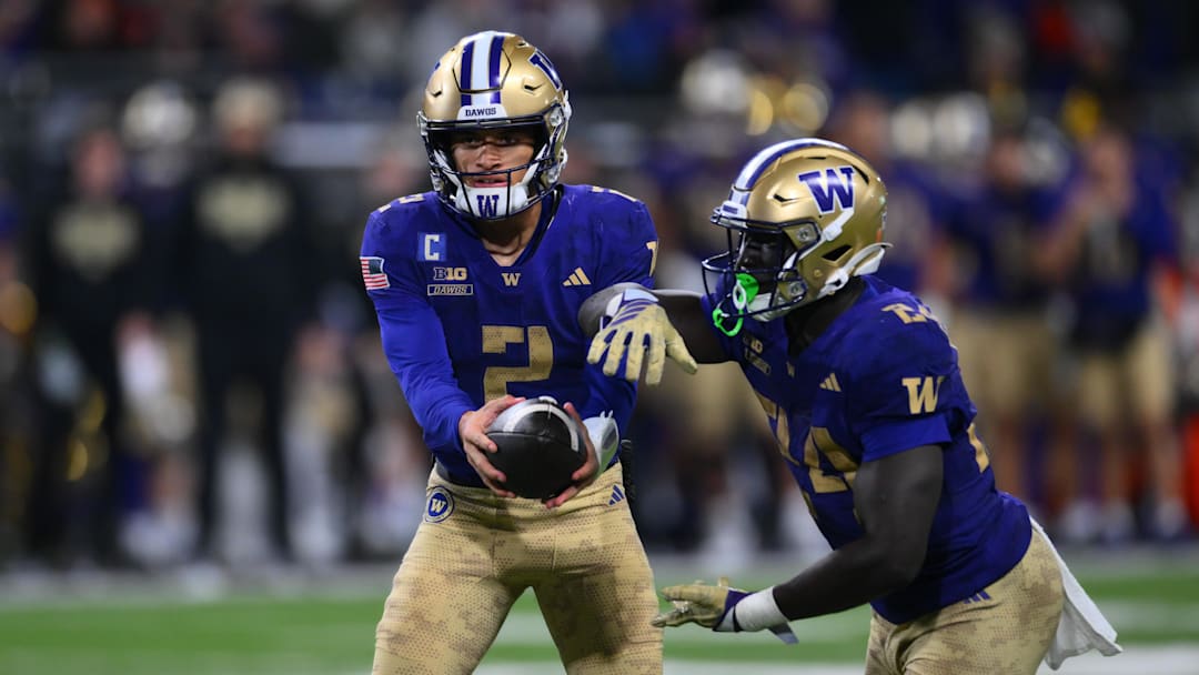 Nov 15, 2025; Seattle, Washington, USA; Washington Huskies quarterback Demond Williams Jr. (2) hands the ball to running back Adam Mohammed (24) during the first half against the Purdue Boilermakers at Husky Stadium. Mandatory Credit: Steven Bisig-Imagn Images Nov 15, 2025; Seattle, Washington, USA; Washington Huskies quarterback Demond Williams Jr. (2) hands the ball to running back Adam Mohammed (24) during the first half against the Purdue Boilermakers at Husky Stadium. Mandatory Credit: Steven Bisig-Imagn Images
