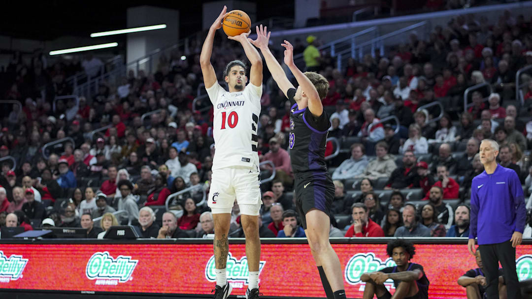 Nov 3, 2025; Cincinnati, Ohio, USA;  Cincinnati Bearcats guard Shon Abaev (10) attempts a 3-point shot against Western Carolina Catamounts forward Marcus Kell (23) in the first half at Fifth Third Arena. Mandatory Credit: Aaron Doster-Imagn Images