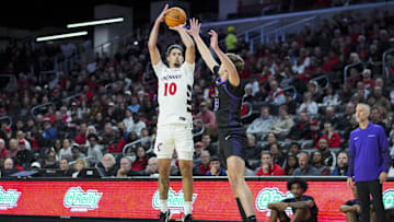 Nov 3, 2025; Cincinnati, Ohio, USA;  Cincinnati Bearcats guard Shon Abaev (10) attempts a 3-point shot against Western Carolina Catamounts forward Marcus Kell (23) in the first half at Fifth Third Arena. Mandatory Credit: Aaron Doster-Imagn Images
