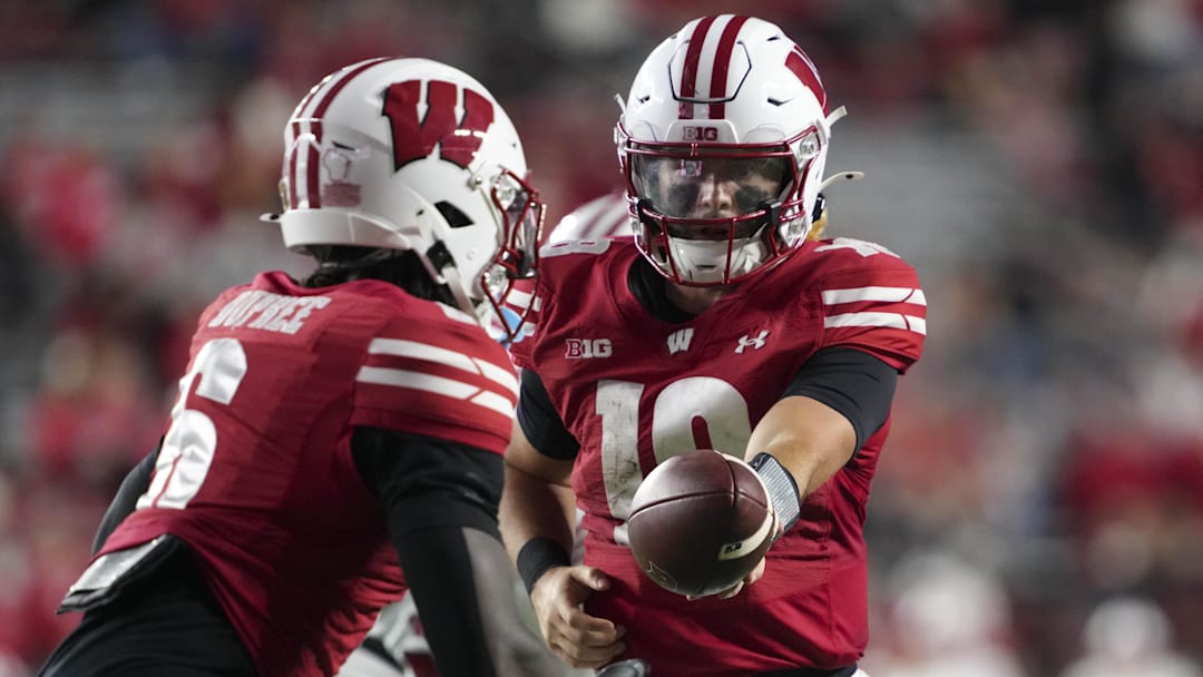Aug 28, 2025; Madison, Wisconsin, USA;  Wisconsin Badgers quarterback Danny O'Neil (18) hands the football off to running back Darrion Dupree (6) during the fourth quarter against the Miami (OH) RedHawks at Camp Randall Stadium. Mandatory Credit: Jeff Hanisch-Imagn Images