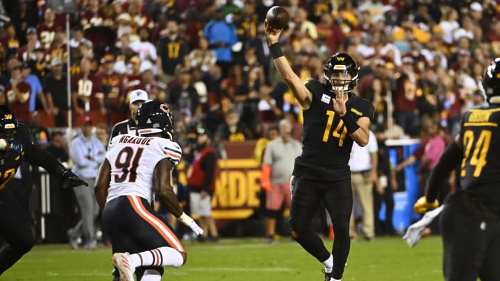 Oct 5, 2023; Landover, Maryland, USA; Washington Commanders quarterback Sam Howell (14) passes over Chicago Bears defensive end Yannick Ngakoue (91) during the second half at FedExField. Mandatory Credit: Brad Mills-USA TODAY Sports