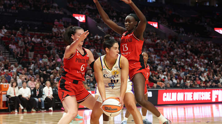 May 3, 2026; Portland, OR, USA;  Portland Fire forward Bridget Carleton (6) and forward Nyadiew Puoch (13) defend Los Angeles Sparks guard Kelsey Plum (10) in the first half at Moda Center. Mandatory Credit: Jaime Valdez-Imagn Images