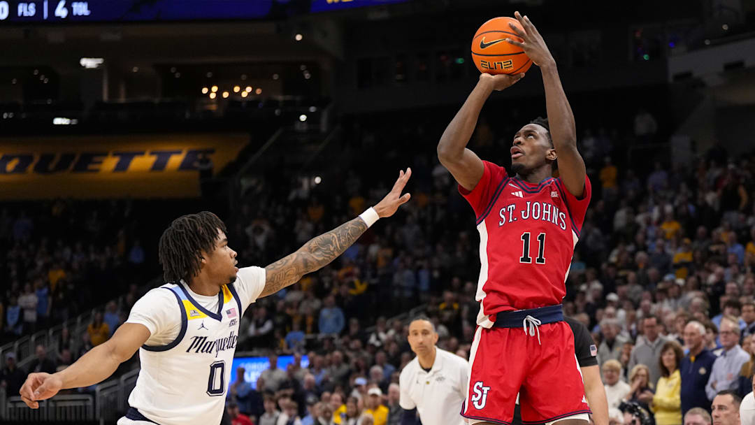 Feb 18, 2026; Milwaukee, Wisconsin, USA;  St. John’s basketball guard Ian Jackson (11) shoots over Marquette Golden Eagles guard Nigel James Jr. (0) during the first half at Fiserv Forum