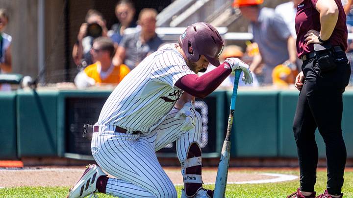 Jun 23, 2024; Omaha, NE, USA; Texas A&M Aggies third baseman Gavin Grahovac (9) kneels while talking with a staffer during the first inning against the Tennessee Volunteers at Charles Schwab Field Omaha. Mandatory Credit: Dylan Widger-Imagn Images