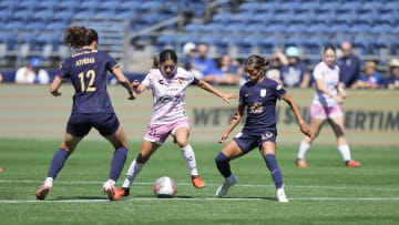 Jul 28, 2024; Seattle, Washington, USA;  Tijuana midfielder Inglis Hernandez (21) controls the ball while being defended by Seattle Reign FC midfielder Olivia Athens (12) and midfielder Sam Meza (20) during the first half at Lumen Field. Mandatory Credit: Stephen Brashear-USA TODAY Sports