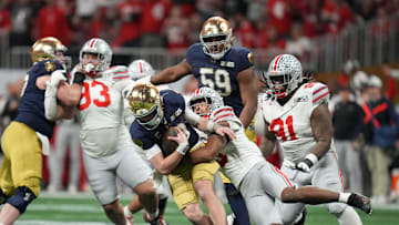 Jan 20, 2025; Atlanta, GA, USA; Notre Dame Fighting Irish quarterback Riley Leonard (13) is sacked by Ohio State Buckeyes safety Sonny Styles (6) in the second half in the CFP National Championship college football game at Mercedes-Benz Stadium. Mandatory Credit: Kirby Lee-Imagn Images