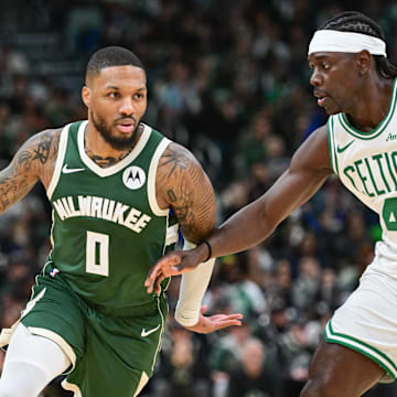 Nov 10, 2024; Milwaukee, Wisconsin, USA; Milwaukee Bucks guard Damian Lillard (0) drives for the basket against Boston Celtics guard Jrue Holiday (4) in the first quarter at Fiserv Forum. Mandatory Credit: Benny Sieu-Imagn Images