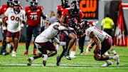 Sep 27, 2025; Raleigh, North Carolina, USA; North Carolina State Wolfpack wide receiver Terrell Anderson (9) is tackled by Virginia Tech Hokies cornerback Isaiah Brown-Murray (9), and linebacker Noah Chambers (16) during the first half of the game against Virginia Tech Hokies at Carter-Finley Stadium. Mandatory Credit: Jaylynn Nash-Imagn Images
