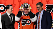 Jun 28, 2023; Nashville, Tennessee, USA; Philadelphia Flyers draft pick Matvei Michkov puts on his hat after being selected with the seventh pick in round one of the 2023 NHL Draft at Bridgestone Arena. Mandatory Credit: Christopher Hanewinckel-USA TODAY Sports