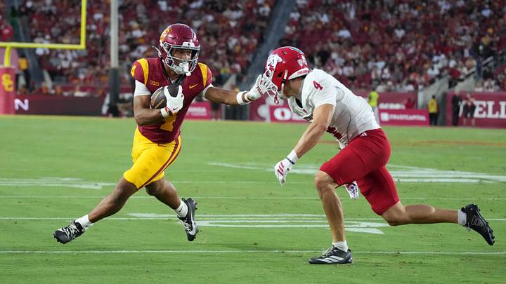 Sep 4, 2026; Los Angeles, California, USA; Southern California Trojans wide receiver Trent Mosley (4) carries the ball on a 9-yard touchdown rexeption against Fresno State Bulldogs defensive back Ethan Tierney (4) in the first half at United Airlines Field at Los Angeles Memorial Coliseum. Mandatory Credit: Kirby Lee-Imagn Images