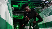 New York Jets cornerback Sauce Gardner signs an autograph for a fan before a game. 