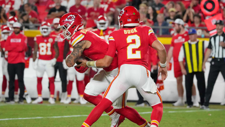 Aug 22, 2024; Kansas City, Missouri, USA; Kansas City Chiefs quarterback Ian Book (2) hands off to running back Louis Rees-Zammit (9) against the Chicago Bears during the game at GEHA Field at Arrowhead Stadium. Mandatory Credit: Denny Medley-USA TODAY Sports