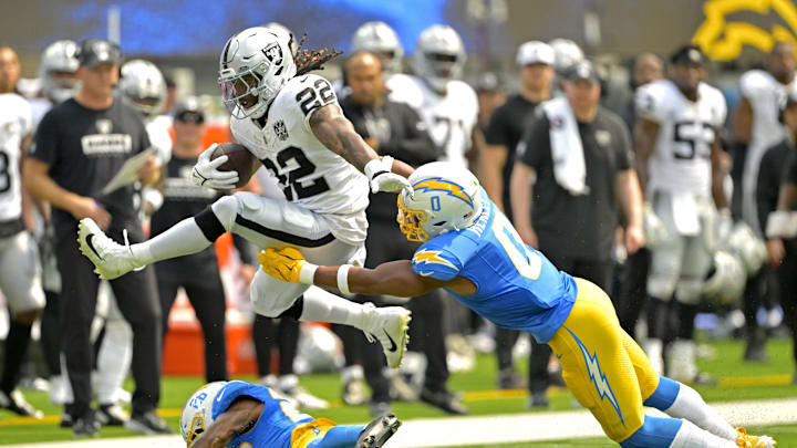 Sep 8, 2024; Inglewood, California, USA; Las Vegas Raiders running back Alexander Mattison (22) gets past Los Angeles Chargers linebacker Daiyan Henley (0) and hurdles over cornerback Asante Samuel Jr. (26) as he runs for a touchdown in the first half at SoFi Stadium. Mandatory Credit: Jayne Kamin-Oncea-Imagn Images