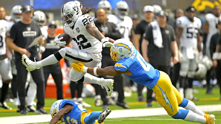 Sep 8, 2024; Inglewood, California, USA; Las Vegas Raiders running back Alexander Mattison (22) gets past Los Angeles Chargers linebacker Daiyan Henley (0) and hurdles over cornerback Asante Samuel Jr. (26) as he runs for a touchdown in the first half at SoFi Stadium. Mandatory Credit: Jayne Kamin-Oncea-Imagn Images