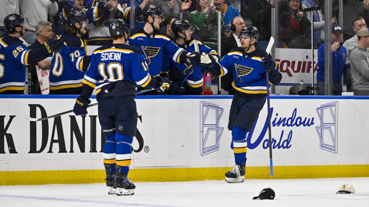 Feb 22, 2024; St. Louis, Missouri, USA;  St. Louis Blues left wing Pavel Buchnevich (89) is congratulated by teammates as hats fall on the ice after scoring a hat trick against the New York Islanders during the third period at Enterprise Center. Mandatory Credit: Jeff Curry-USA TODAY Sports