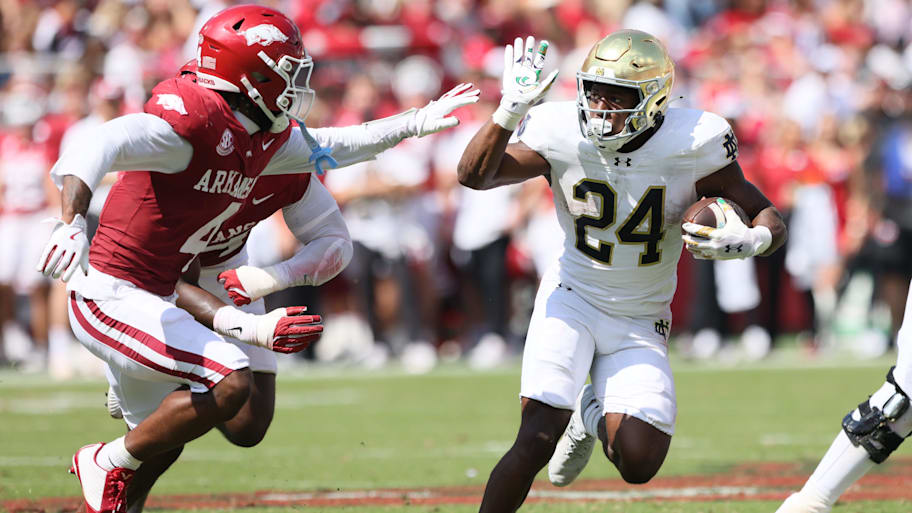 Notre Dame running back Jadarian Price rushes during the third quarter as Arkansas defensive back Jordan Young closes in.