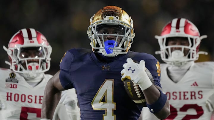 Notre Dame Fighting Irish running back Jeremiyah Love (4) scores a touchdown while being chased by Indiana Hoosiers defensive back D'Angelo Ponds (5) and Indiana Hoosiers defensive back Jamari Sharpe (22) during the first half of a game between the Indiana Hoosiers and the Notre Dame Fighting Irish in first round of the College Football Playoff on Friday, Dec. 20, 2024, in South Bend.