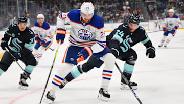 Edmonton Oilers center Leon Draisaitl (29) protects the puck from Seattle Kraken defenseman Jamie Oleksiak (24)