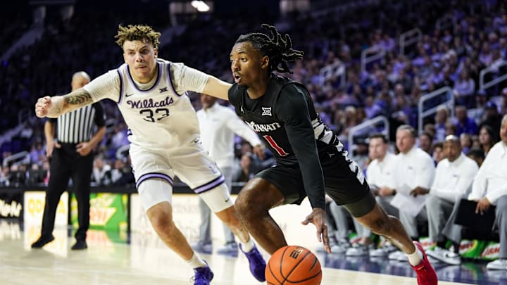 Dec 30, 2024; Manhattan, Kansas, USA; Cincinnati Bearcats guard Day Day Thomas (1) drives against Kansas State Wildcats guard Coleman Hawkins (33) during the first half at Bramlage Coliseum. Mandatory Credit: Jay Biggerstaff-Imagn Images Dec 30, 2024; Manhattan, Kansas, USA; Cincinnati Bearcats guard Day Day Thomas (1) drives against Kansas State Wildcats guard Coleman Hawkins (33) during the first half at Bramlage Coliseum. Mandatory Credit: Jay Biggerstaff-Imagn Images