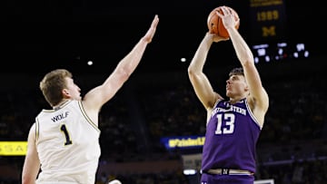 Jan 19, 2025; Ann Arbor, Michigan, USA;  Northwestern Wildcats guard Brooks Barnhizer (13) shoots over Michigan Wolverines center Danny Wolf (1) in the second half at Crisler Center. Mandatory Credit: Rick Osentoski-Imagn Images