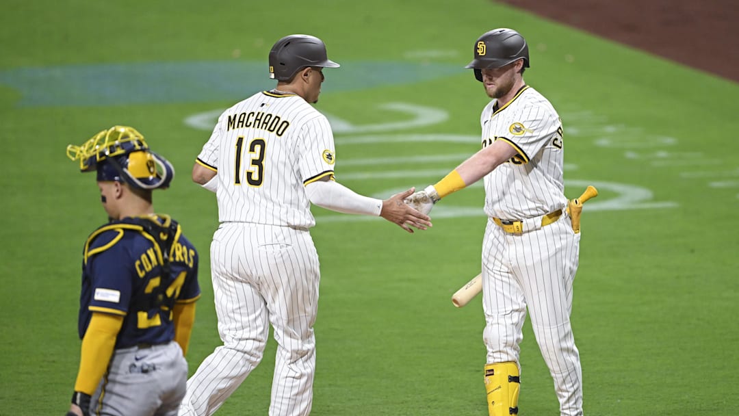 Sep 22, 2025; San Diego, California, USA; San Diego Padres third baseman Manny Machado (13) is congratulated by Jake Cronenworth (9) after scoring during the first inning against the Milwaukee Brewers at Petco Park. Mandatory Credit: Denis Poroy-Imagn Images Sep 22, 2025; San Diego, California, USA; San Diego Padres third baseman Manny Machado (13) is congratulated by Jake Cronenworth (9) after scoring during the first inning against the Milwaukee Brewers at Petco Park. Mandatory Credit: Denis Poroy-Imagn Images
