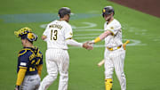 Sep 22, 2025; San Diego, California, USA; San Diego Padres third baseman Manny Machado (13) is congratulated by Jake Cronenworth (9) after scoring during the first inning against the Milwaukee Brewers at Petco Park. Mandatory Credit: Denis Poroy-Imagn Images
