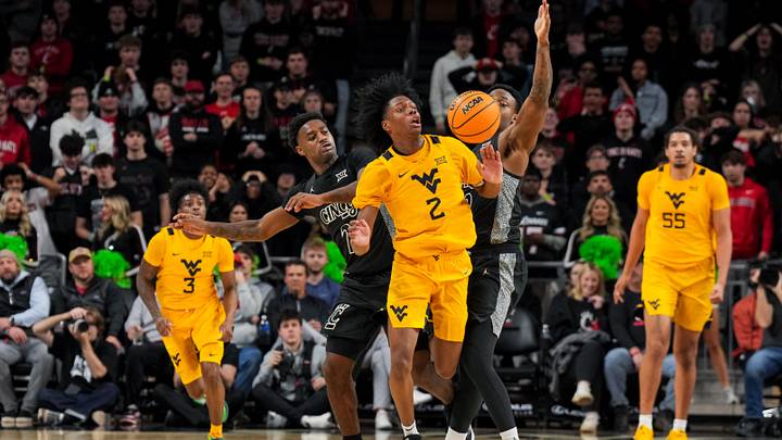 Feb 5, 2026; Cincinnati, Ohio, USA;  West Virginia Mountaineers guard Amir Jenkins (2) steals the ball away from Cincinnati Bearcats guard Jizzle James (2) and forward Jalen Celestine (32) in the second half at Fifth Third Arena. Mandatory Credit: Aaron Doster-Imagn Images