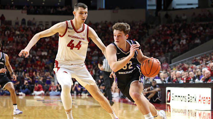 Dec 14, 2024; North Little Rock, Arkansas, USA; UCA Bears guard Layne Taylor (32) drives against Arkansas Razorbacks forward Zvonmiri Ivisic (44) during the first half at Simmons Bank Arena. Mandatory Credit: Nelson Chenault-Imagn Images