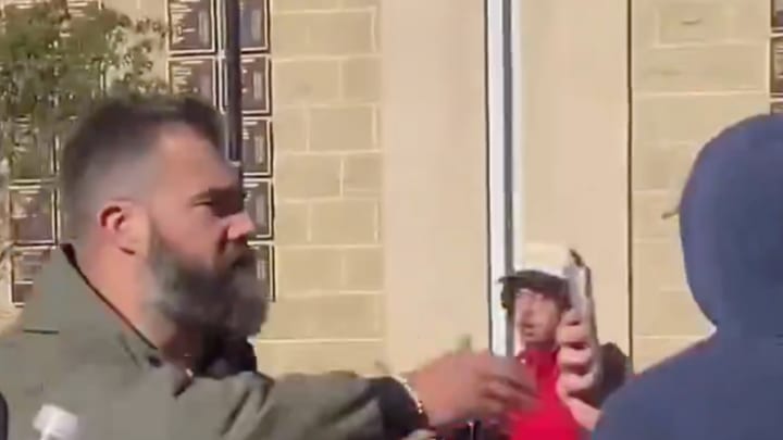 Former Philadelphia Eagles center and current ESPN analyst Jason Kelce reaches for a heckling fan's phone moments before smashing it onto the ground before an appearance on ESPN's College Gameday on the campus of Penn State University on Saturday. 
