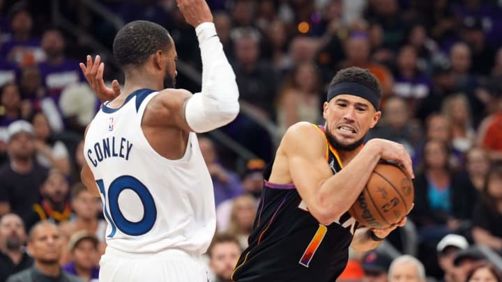 Apr 26, 2024; Phoenix, Arizona, USA; Phoenix Suns guard Devin Booker (1) drives against Minnesota Timberwolves guard Mike Conley (10) during the second half of game three of the first round for the 2024 NBA playoffs at Footprint Center. Mandatory Credit: Joe Camporeale-USA TODAY Sports