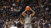 Mar 8, 2025; Morgantown, West Virginia, USA; West Virginia Mountaineers forward Amani Hansberry (13) shoots a three pointer during the first half against the UCF Knights at WVU Coliseum. Mandatory Credit: Ben Queen-Imagn Images