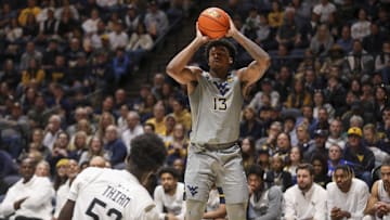 Mar 8, 2025; Morgantown, West Virginia, USA; West Virginia Mountaineers forward Amani Hansberry (13) shoots a three pointer during the first half against the UCF Knights at WVU Coliseum. Mandatory Credit: Ben Queen-Imagn Images