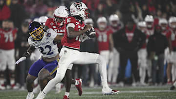 Dec 28, 2024; Annapolis, MD, USA;  North Carolina State Wolfpack quarterback CJ Bailey (16)] scrambles away from East Carolina Pirates linebacker Ryheem Craig (32) during the first half of the Go Bowling Military Bowl at Navy-Marine Corps Memorial Stadium. Mandatory Credit: Tommy Gilligan-Imagn Images