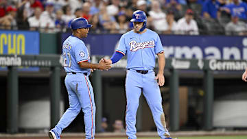 Aug 24, 2025; Arlington, Texas, USA; Texas Rangers third base coach Tony Beasley (27) and center fielder Wyatt Langford (36) tap fists after Langford steals third base during the first inning against the Cleveland Guardians at Globe Life Field. 