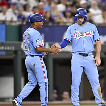 Aug 24, 2025; Arlington, Texas, USA; Texas Rangers third base coach Tony Beasley (27) and center fielder Wyatt Langford (36) tap fists after Langford steals third base during the first inning against the Cleveland Guardians at Globe Life Field. 