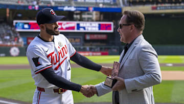 Minnesota Twins pitcher Pablo López (49) shakes hands with Minnesota Twins executive President of Baseball Operations Derek Falvey.