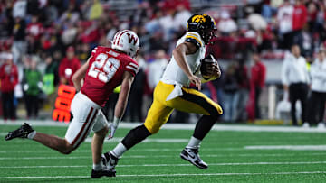 Oct 11, 2025; Madison, Wisconsin, USA; Iowa Hawkeyes quarterback Mark Gronowski (11) runs the ball while being chased by Wisconsin Badgers safety Matthew Jung (29) during the second half at Camp Randall Stadium. Mandatory Credit: Ross Harried-Imagn Images