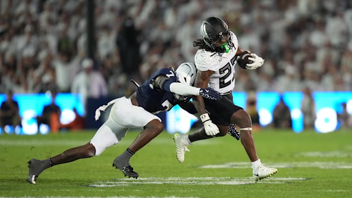 Sep 27, 2025; University Park, Pennsylvania, USA; Oregon Ducks running back Dierre Hill Jr. (23) is tackled by Penn State Nittany Lions cornerback Zion Tracy (7) during the third quarter at Beaver Stadium. Mandatory Credit: James Lang-Imagn Images
