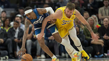 Apr 25, 2025; Minneapolis, Minnesota, USA; Minnesota Timberwolves forward Jaden McDaniels (3) and Los Angeles Lakers guard Luka Doncic (77) fight for the ball in the first half during game three of first round for the 2024 NBA Playoffs at Target Center. Mandatory Credit: Jesse Johnson-Imagn Images