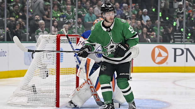 Hockey player in green uniform stands near the ne