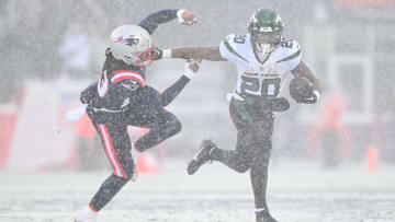 Jan 7, 2024; Foxborough, Massachusetts, USA; New York Jets running back Breece Hall (20) breaks a tackle from New England Patriots safety Kyle Dugger (23) during the first half at Gillette Stadium. Mandatory Credit: Brian Fluharty-Imagn Images