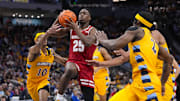Dec 7, 2024; Milwaukee, Wisconsin, USA; Wisconsin Badgers guard John Blackwell (25) drives for the basket during the first half against the Marquette Golden Eagles at Fiserv Forum.