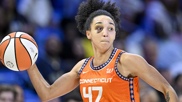 Lacan getting ready to throw a ball in an orange jersey with blue linin