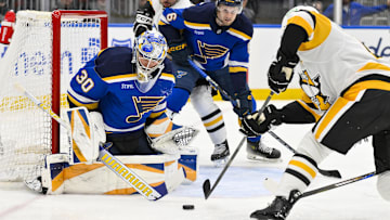 Apr 3, 2025; St. Louis, Missouri, USA;  St. Louis Blues goaltender Joel Hofer (30) defends the net against Pittsburgh Penguins right wing Bryan Rust (17) during the first period at Enterprise Center. Mandatory Credit: Jeff Curry-Imagn Images