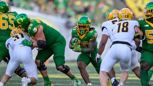 Aug 31, 2024; Eugene, Oregon, USA; Oregon Ducks running back Jordan James (20) runs behind a block by offensive lineman Charl