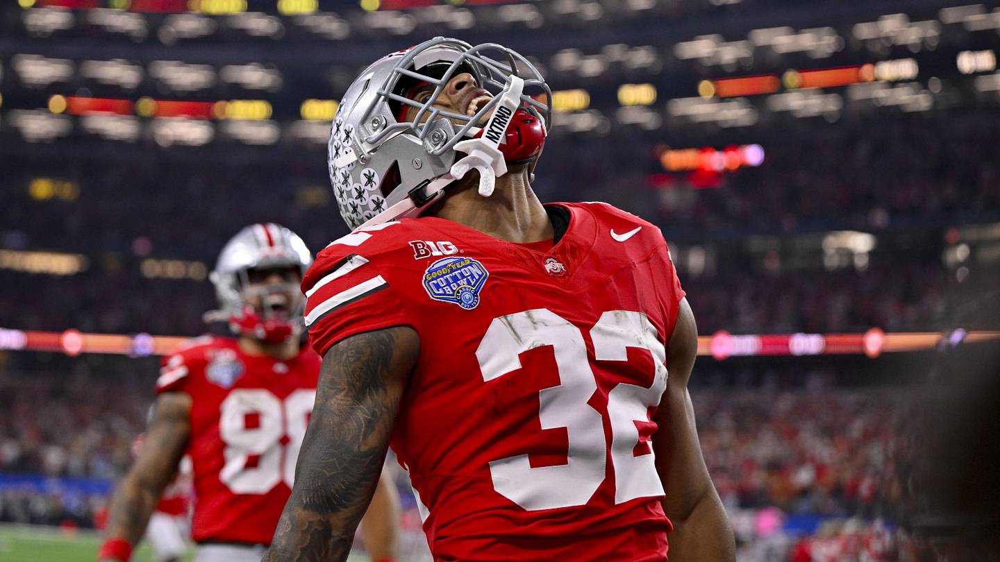 Treveyon Henderson sprinting past defenders, Ohio State uniform gleaming under stadium lights, fantasy points soaring.
