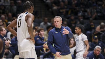 Nov 17, 2025; Morgantown, West Virginia, USA; West Virginia Mountaineers head coach Ross Hodge talks to West Virginia Mountaineers forward Brenen Lorient (0) during the first half against the Lafayette Leopards at WVU Coliseum. Mandatory Credit: Ben Queen-Imagn Images