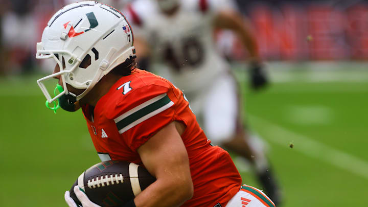 Sep 14, 2024; Miami Gardens, Florida, USA; Miami Hurricanes wide receiver Xavier Restrepo (7) runs with the football against the Ball State Cardinals during the first quarter at Hard Rock Stadium. Mandatory Credit: Sam Navarro-Imagn Images